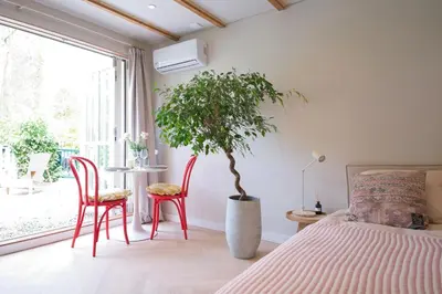 a bedroom with a bed and a table and chairs at B&B Goldie in Aerdenhout