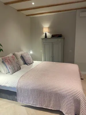 a bedroom with a large bed with a striped blanket at B&B Goldie in Aerdenhout