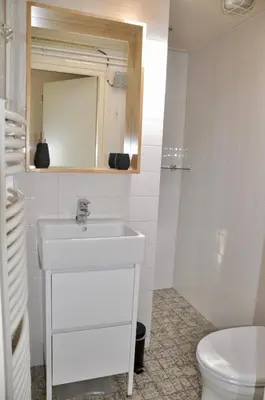 a white bathroom with a sink and a toilet at Garnekuul 34 in Ons Belang