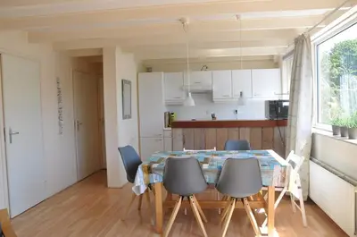 a kitchen and dining room with a table and chairs at Garnekuul 34 in Ons Belang