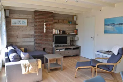 a living room with a couch and a tv at Garnekuul 34 in Ons Belang