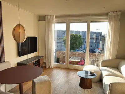a living room with a couch and a table at Appartement Huis ter Duinstraat in Noordwijk aan Zee