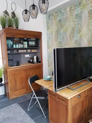 a television on a wooden desk with a table at B&B Purmavida in Purmerend