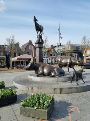 a statue of a cow laying on a fountain at B&B Purmavida in Purmerend