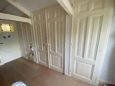an empty room with white doors and wood floors at Fantastic house with a large roof terrace downtown in Alkmaar