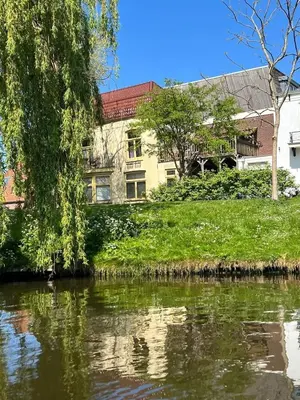 a building on the side of a river at Fantastic house with a large roof terrace downtown in Alkmaar