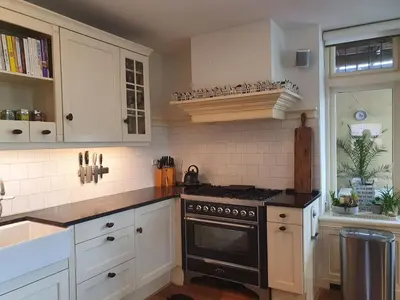 a kitchen with white cabinets and a stove top oven at Fantastic house with a large roof terrace downtown in Alkmaar