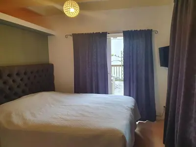 a bedroom with a bed and a window with blue curtains at Fantastic house with a large roof terrace downtown in Alkmaar