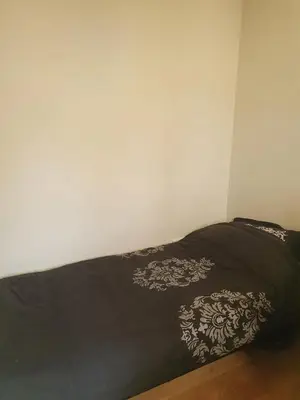 a bed in a room with a black blanket at Fantastic house with a large roof terrace downtown in Alkmaar