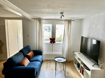 a living room with a blue couch and a television at Cozy Apartment in Aalsmeer in Aalsmeer