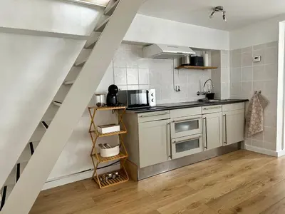 a kitchen with white cabinets and a staircase at Cozy Apartment in Aalsmeer in Aalsmeer