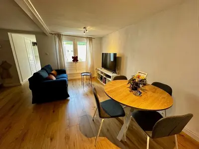 a living room with a table and a couch at Cozy Apartment in Aalsmeer in Aalsmeer