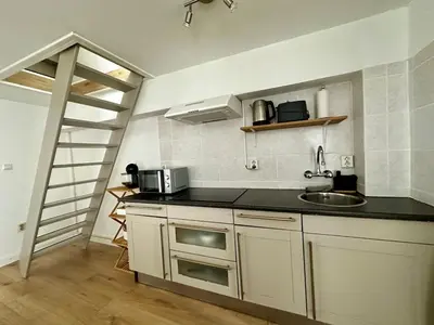 a kitchen with a sink and a staircase in a room at Cozy Apartment in Aalsmeer in Aalsmeer