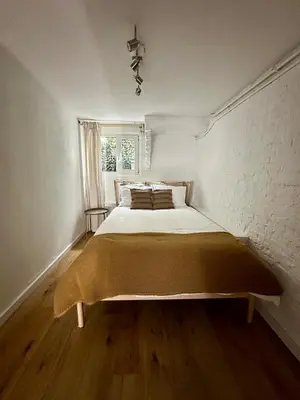 a bed in a white room with a brick wall at Cozy Apartment in Aalsmeer in Aalsmeer
