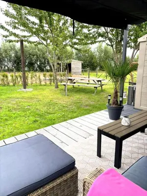 a patio with a bench and a picnic table at De Polderhoeve in Heerhugowaard