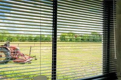 a window with a view of a tractor in a field at De Polderhoeve in Heerhugowaard
