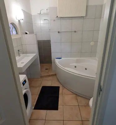 a white bathroom with a tub and a sink at Guesthouse 10 in Schellinkhout