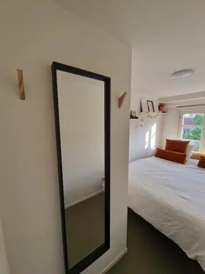 a mirror on a wall next to a bed at Modern and cozy, top location in Amsterdam