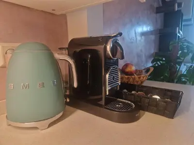 a coffee maker sitting on a counter next to a basket of fruit at Modern and cozy, top location in Amsterdam