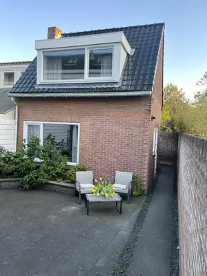 a house with two chairs and a table in front of it at Wendy's Tiny Beachhouse in Noordwijk