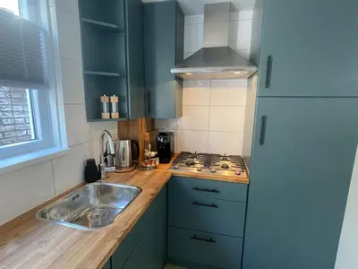 a kitchen with a sink and a stove at Wendy's Tiny Beachhouse in Noordwijk