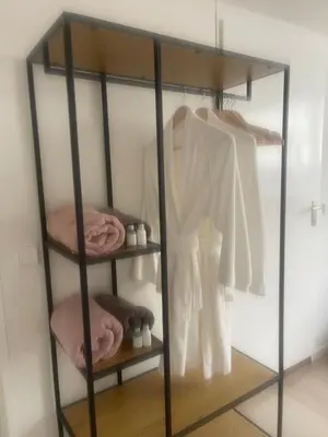 a glass shelf with clothes and towels on it at Wendy's Tiny Beachhouse in Noordwijk