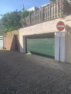 a garage with a green door in a brick building at Studio Alexander with private indoor parking in Zandvoort