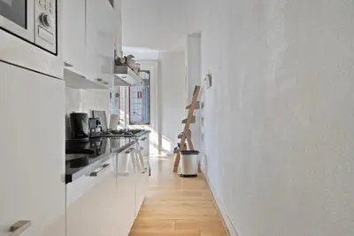 a kitchen with white walls and a wooden floor at Authentic stay in Alkmaar in Alkmaar