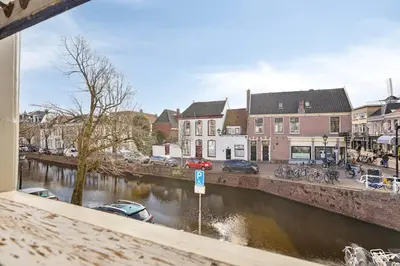 a river with cars parked on the side of it at Authentic stay in Alkmaar in Alkmaar