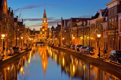 a city street with a river with a clock tower at Authentic stay in Alkmaar in Alkmaar