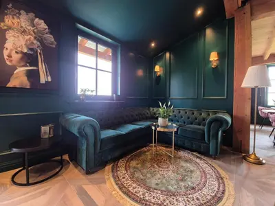 a living room with a green couch and a table at Bed and Breakfast Zomerzicht in Oudendijk