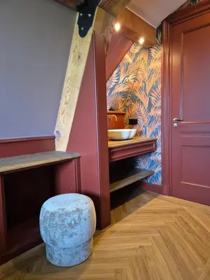 a small kitchen with a stool and a staircase at Bed and Breakfast Zomerzicht in Oudendijk