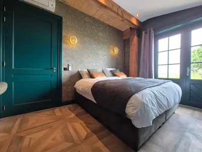 a bedroom with a bed and a green door at Bed and Breakfast Zomerzicht in Oudendijk
