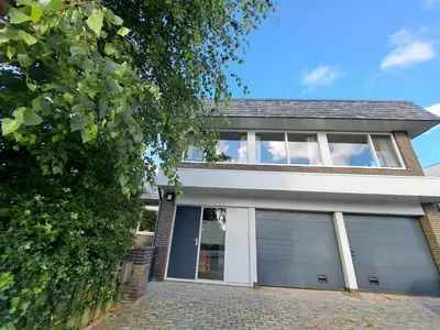 a house with two garage doors on it at Chang in Egmond aan den Hoef