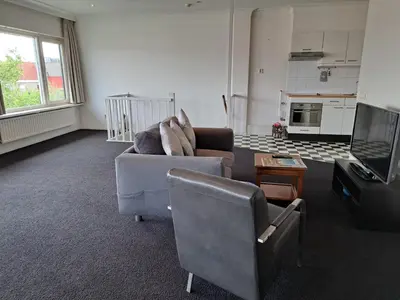 a living room with a couch and a chair and a tv at Chang in Egmond aan den Hoef