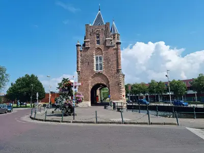 a brick building with a tower with a gate at B&B De Amsterdamse Poort in Haarlem