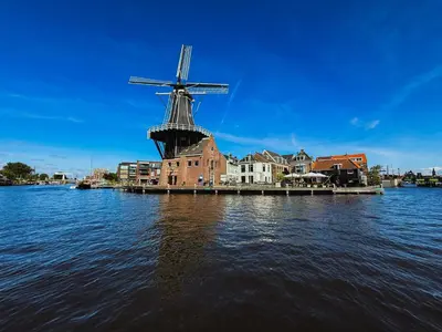 a windmill in the middle of a body of water at B&B De Amsterdamse Poort in Haarlem