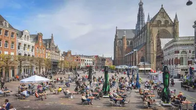a crowd of people sitting in chairs in a city street at B&B De Amsterdamse Poort in Haarlem