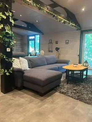 a living room with a couch and a table at Onder de hanebalken in Dirkshorn