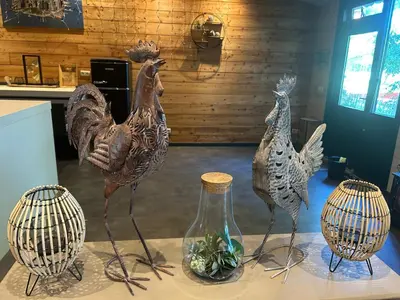 three statues of chickens and a vase on a table at Onder de hanebalken in Dirkshorn