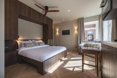 a bedroom with a bed and a desk and a window at Boutique Studio VO38 in Alkmaar