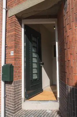 a green door in a brick building with a brick wall at Boutique Studio VO38 in Alkmaar