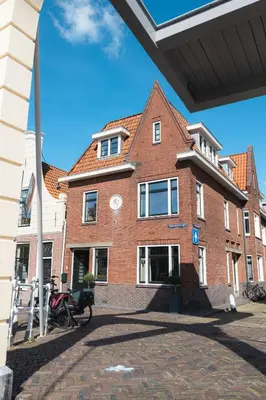 a large brick building with a clock on it at Boutique Studio VO38 in Alkmaar