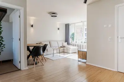 a white living room with a white couch and a table at B&b aan zee in Egmond aan Zee