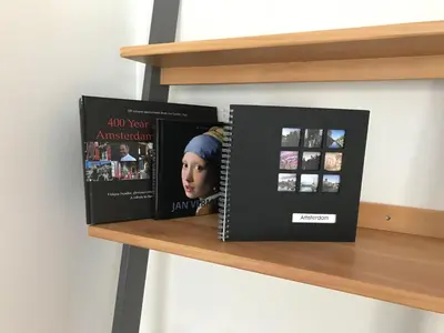 three books are sitting on a shelf at Rust B&B in Amsterdam