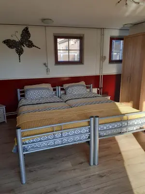 a bed in a room with a butterfly on the wall at Dirosa in Onderdijk