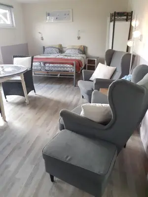 a living room with a couch and chairs and a bed at Dirosa in Onderdijk
