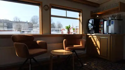 two chairs and a table in a room with a window at Botel Clair d'Etoile in Amsterdam