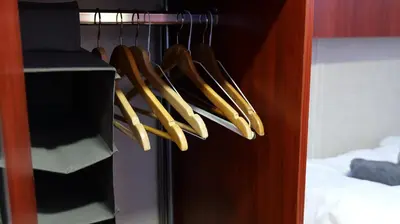a closet filled with wooden hangers with baseball bats at Botel Clair d'Etoile in Amsterdam