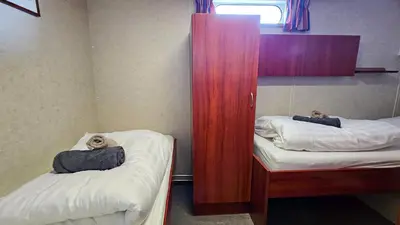 a room with two beds and a cabinet with two bears on them at Botel Clair d'Etoile in Amsterdam